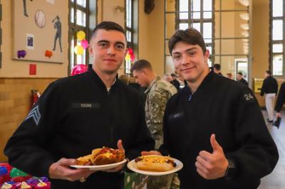 Two students, known as cadets, at ֻ̳enjoy a hot dog event in Crozet Hall celebrating MLB opening day.