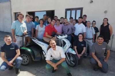 Study abroad students - cadets from ֻ̳- pose with prototype electric vehicle in Italy.