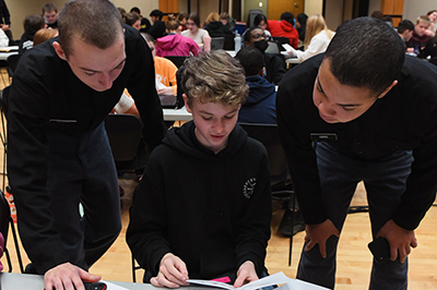 ֻ̳students, known as cadets, work with an area middle school math student as part of a problem-solving program at a military college in Virginia.